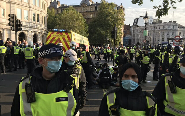 Picture taken with permission from the twitter feed of @bollin_anne of police officers tending to person injured during an anti-vax protest in London's Trafalgar Square.