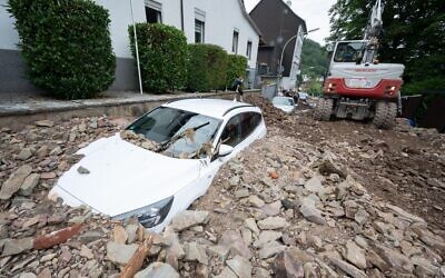 A car is buried by rubble in the Hohenlimburg district of Hagen, western Germany. (Photo: Julian Stratenschulte/dpa)