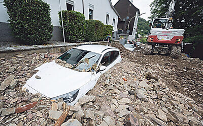 A car is buried by rubble in the Hohenlimburg district. Credit: Julian Stratenschulte/dpa/Alamy Live News