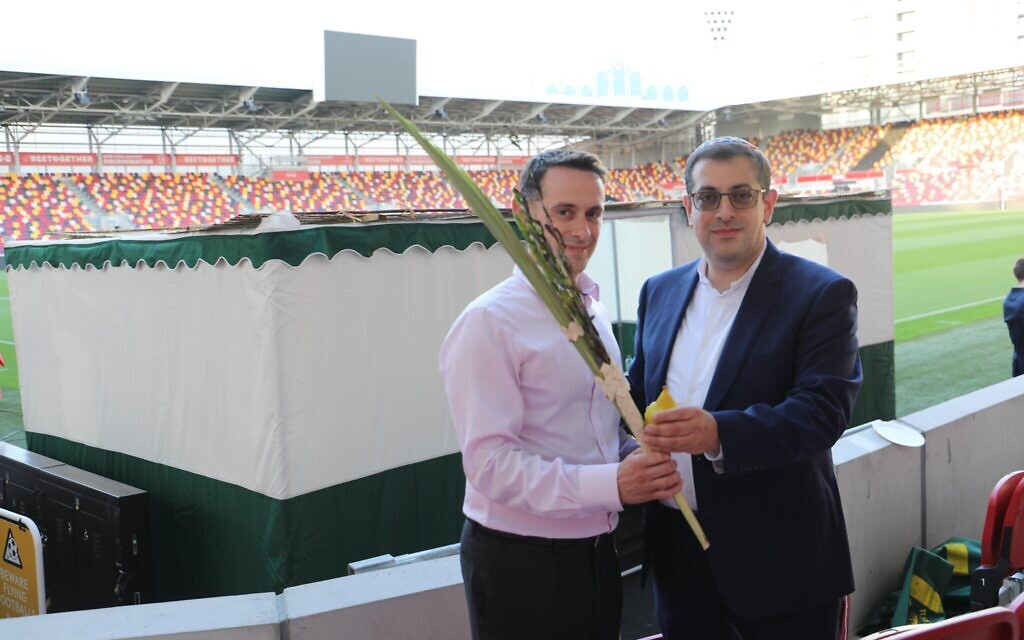 Kevin Coleman (left) shakes a lulav and etrog with Rabbi Goldberg