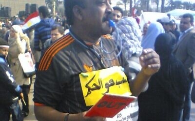Photo in February 2011 taken by Khalid, in Tahrir Square in Egypt. The individual in the photo is dressed like a referee and has a sign that reads "the people are the referee".