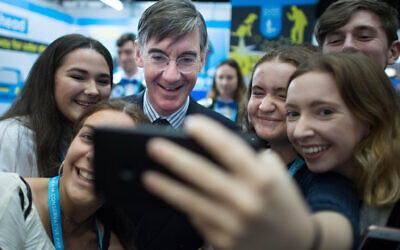Leader of the House of Commons Jacob Rees-Mogg poses for a photograph with young people during the Conservative Party Conference at the Manchester Convention Centre.