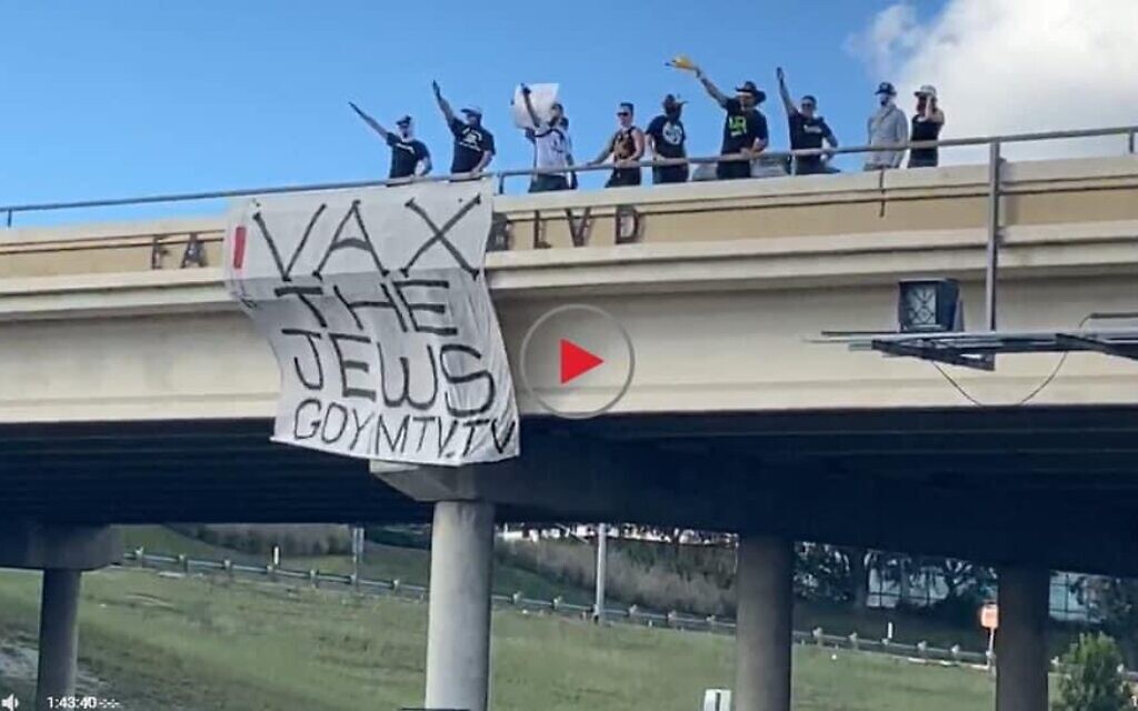 Image of far-right protestors hanging a 'van the Jews' banner (Credit: @ChristineTX34 on Twitter)