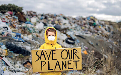 Small child holding placard poster on a landfill
