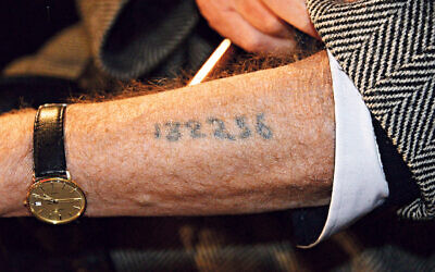 A Holocaust survivor displaying his arm tattoo