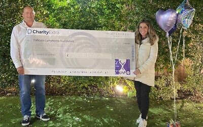 Nicola Mendelsohn and Lord Jon Mendelsohn pose with a cheque after the fundraising effort