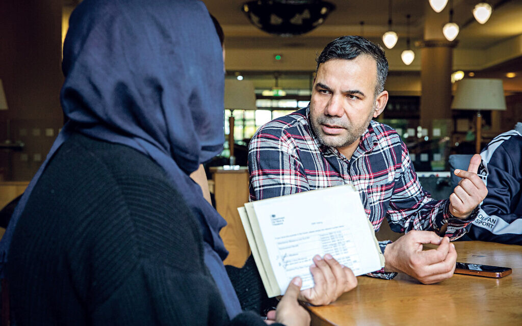 'Safia' a support worker who speaks 5 different  languages works on the Afghan wrap around program working with one of the Familes to help them with calls to HMRC. Horton Housing supporting Afghan families that have recently arrived in the United Kingdom through the Afghanistan resettlement scheme,  Bradford, United Kingdom.  Many of the people in this scheme were evacuated from Afghanistan when the Taliban took over,  they were working for the British Army as translators and doing other supporting roles. (photo by Andy Aitchison)