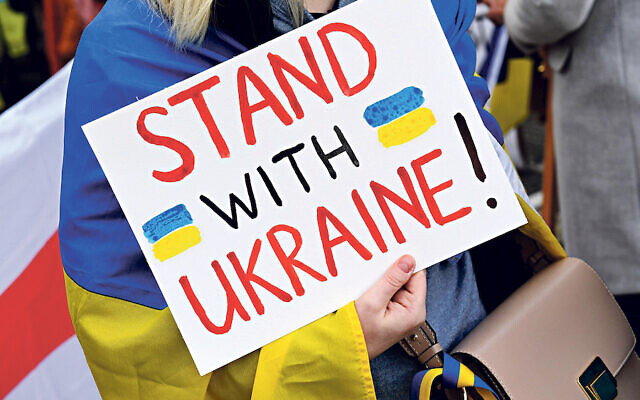 A demonstrator stands with a placard Stand with Ukraine!  stands at a demonstration for Ukraine during the security conference at Odeonsplatz. The focus of the three-day security policy forum is the Ukraine crisis. Credit: Felix Horhager/dpa/Alamy Live News