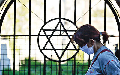 A woman passes by the Star of David (Photo by Artur Widak/NurPhoto)
