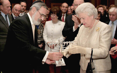 The Queen is presented with a Chanukiah by Chief Rabbi Jonathan Sacks in 2006.  (AP Photo/Andrew Parsons, Pool)