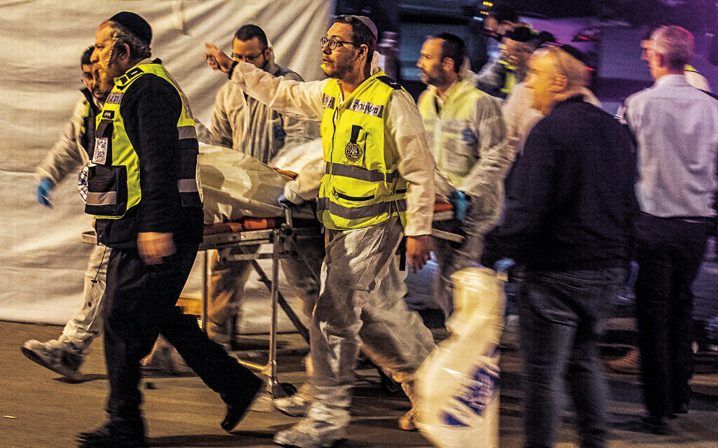 Hadera, Israel. 27th Mar, 2022. Medics transport the body of a victim into an ambulance where two people were killed by gunmen in Hadera. Credit: Ilia Yefimovich/dpa - ATTENTION: graphic content/dpa/Alamy Live News