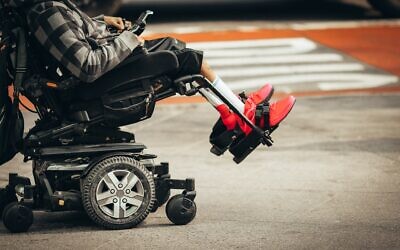 Disabled person in a wheelchair  (Photo by Jon Tyson on Unsplash)