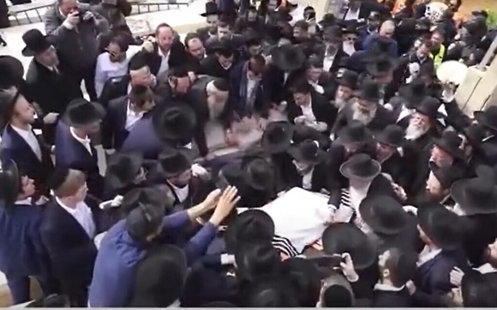 Mourners surround the grave of Rabbi Chaim Kanievsky, at his funeral on 20 March, 2022 (screengrab, Israel's Channel 13)
