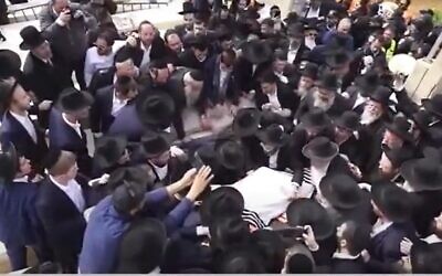 Mourners surround the grave of Rabbi Chaim Kanievsky, at his funeral on 20 March, 2022 (screengrab, Israel's Channel 13)