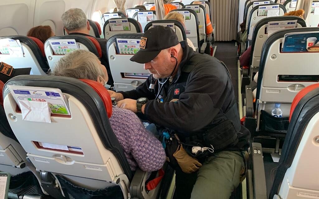 Dr. Zev Neuwirth checking a Ukrainian refugee who suffers from a medical condition while on board a rescue flight as part of Operation Orange Wings