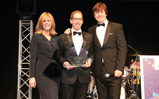 Robert Speker (centre) receives his Care Home Activity Organiser Award from journalist Kate Garraway and compere Steve Walls at the Great British Care Awards 2022 National Finals at the ICC in Birmingham on 18 March, 2022