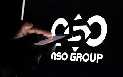 2HMDBT2 Studio photographic illustration shows a person using a smartphone in a dark room with the logo of Israel's NSO Group which features 'Pegasus' spyware in background on February 08, 2022. Israel. Israel's government is set to consider opening a commission of inquiry to look into alleged police use of Pegasus hacking software against Israeli citizens, including politicians and activists.