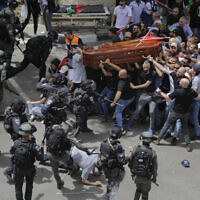 Israeli police confront mourners as they carry the casket of slain Al Jazeera veteran journalist Shireen Abu Akleh during her funeral in east Jerusalem.
