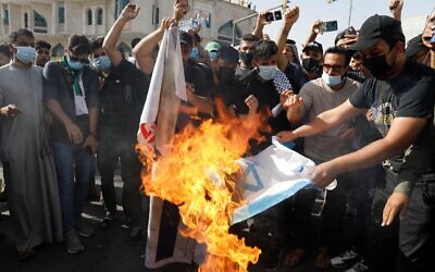 2FN8N4H Iraqi demonstrators burn an Israeli flag during a protest to express solidarity with the Palestinian people amid a flare-up of Israeli-Palestinian violence, in Baghdad, Iraq May 15, 2021. REUTERS/Khalid al-Mousily