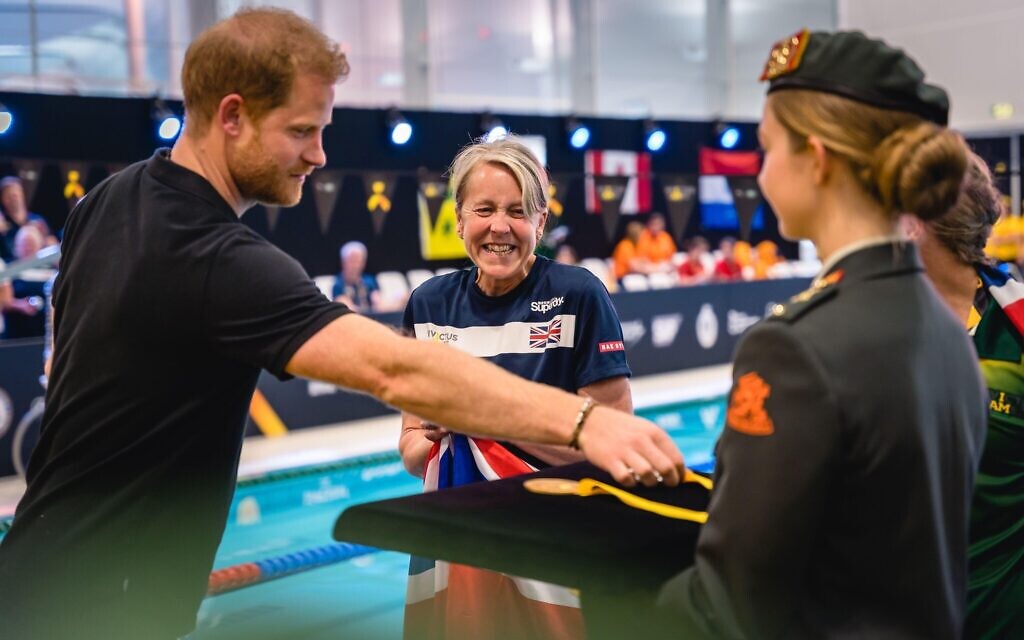 Prince Harry, Duke of Sussex, with a British competitor during the swimming at the Invictus Games at Het Hofbad the Hague, Netherlands, in April 2022 (Photo: Jolanda Aalbers / Alamy)