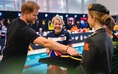 Prince Harry, Duke of Sussex, with a British competitor during the swimming at the Invictus Games at Het Hofbad the Hague, Netherlands, in April 2022 (Photo: Jolanda Aalbers / Alamy)