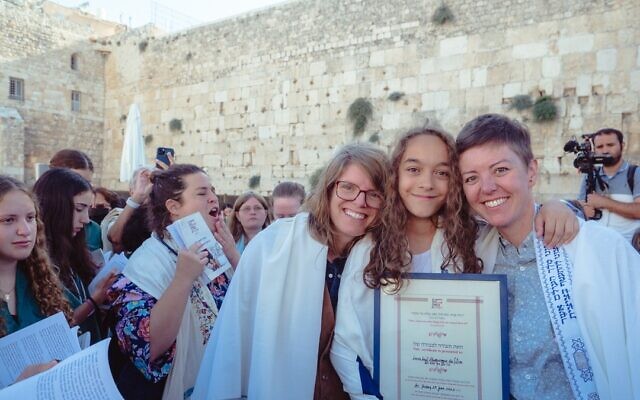 Lucia da Silva, 12, with her proud mothers Cara Stoddard (right) and Ada Danelo (left) in front of the Western Wall, July 29, 2022 (Tal Kfir Shor)