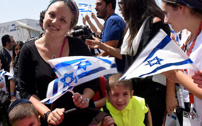 Israelis wave national flags as they greet newly arrived Jewish immigrants on their arrival at Ben Gurion Airport.