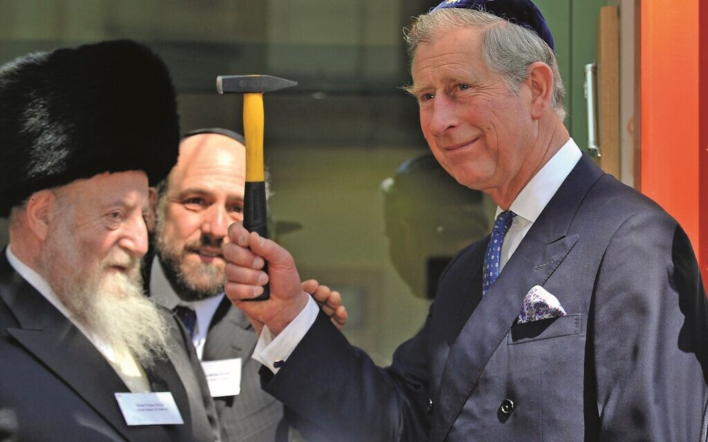 Charles, as Prince of Wales, raises a hammer he used to nail a mezuzah at the Jewish Centre in Krawkow (Photo: Arthur Edwards/The Sun)