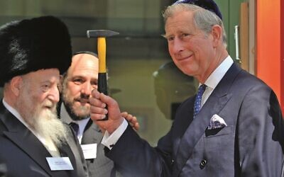 Charles, as Prince of Wales, raises a hammer he used to nail a mezuzah at the Jewish Centre in Krawkow (Photo: Arthur Edwards/The Sun)