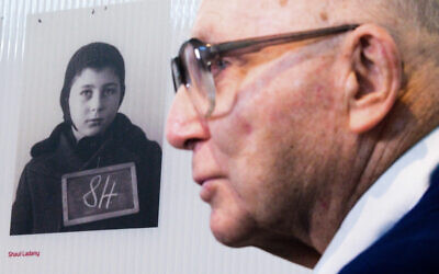Holocaust survivor and Israeli sportsman Shaul Ladany stands in front of a child photo of him in the Bergen-Belsen concentration camp memorial.