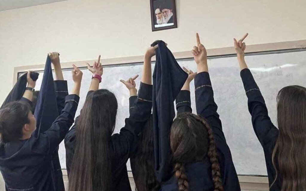 Protesting Iranian school girls raise their middle fingers – an obscene gesture – at the portraits of Ayatollah Khamenei and the founder of the Islamic Republic, Ayatollah Ruhollah Khomeini.
