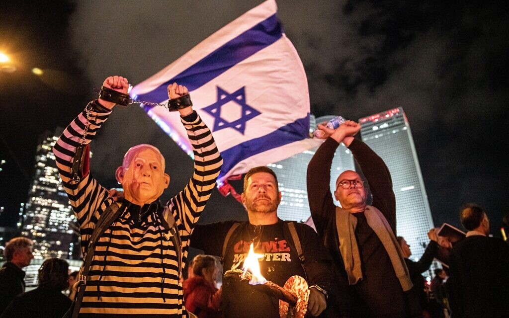Israeli protestor dressed in a convict uniform and wears a Benjamin Netanyahu mask lifts his handcuffed arms in the air next to a Crime Minister protestor. Thousands rally in Tel Aviv to protest against Netanyahu's far-right government and judicial overhaul. Jan 07th 2023. (Photo by Matan Golan/Sipa USA). Credit: Sipa USA/Alamy Live News