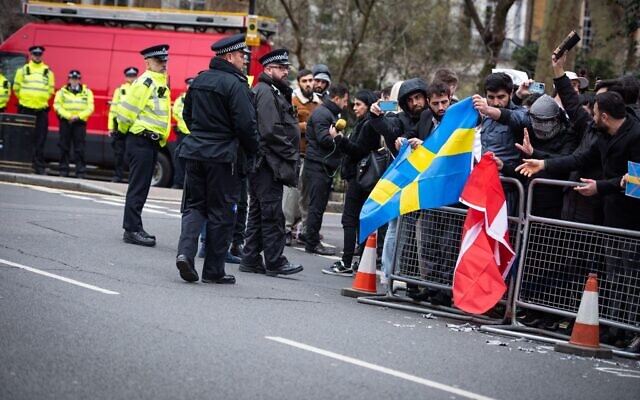 Metropolitan Police stand on guard while protestors prepare to burn the Swedish and Danish flags during the demonstration against the Quran Burning In Sweden. Friday 27 January 2023.