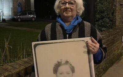 Holocaust survivor Joan Salter hold a picture of herself as a young refugee.