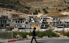 A  settler walks past Israeli settlement construction sites around Givat Zeev and Ramat Givat Zeev in the Israeli-occupied West Bank, near Jerusalem June 30, 2020. REUTERS/Ammar Awad     TPX IMAGES OF THE DAY