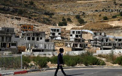 A Jewish settler walks past Israeli settlement construction sites around Givat Zeev and Ramat Givat Zeev in the Israeli-occupied West Bank, near Jerusalem June 30, 2020. REUTERS/Ammar Awad     TPX IMAGES OF THE DAY