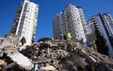 Emergency teams search for people in the rubble of a destroyed building in Adana, southern Turkey, Tuesday, Feb. 7, 2023. A powerful earthquake hit southeast Turkey and Syria early Monday, toppling hundreds of buildings and killing and injuring thousands of people. (AP Photo/Hussein Malla)