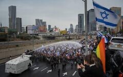 2PHBTK9 Israeli police use a water cannon to disperse Israelis blocking the freeway during a protest against plans by Prime Minister Benjamin Netanyahu's government to overhaul the judicial system in Tel Aviv, Israel, Thursday, March 23, 2023. (AP Photo/Oded Balilty)