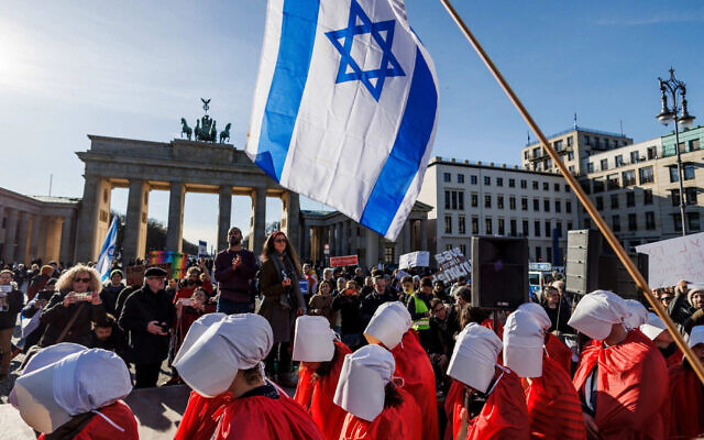 Demonstrators dressed in red costumes inspired by "The Handmaid's Tale" protest against the Israeli government in front of the Brandenburg Gate on the occasion of the Israeli prime minister's visit to Berlin. (Carsten Koall/picture alliance via Getty Images)