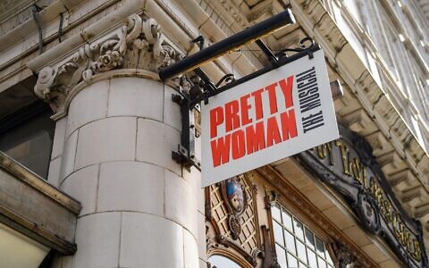 LONDON - May 18, 2022: Pretty Woman The Musical street sign hangs from side of building in London