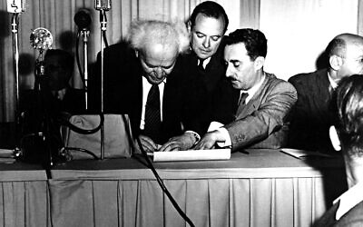 Israeli Prime Minister David Ben Gurion, left, signs a document in Tel Aviv, Palestine, proclaiming the new Jewish State of Israel in Tel Aviv at midnight on May 14, 1948.  Witnessing the ceremony at right is Israel's first Foreign Minister Moshe Sharett,  Zionist pioneer and leader in the establishment of the state of Israel.  The man at center is not identified.  The Jews declared independence in the new state of Israel as the 25-year British mandate over Palestine ends.  (AP Photo)