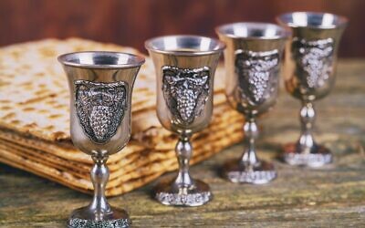 Red kosher four glasses wine with a of matzah a Passover Haggadah on a vintage wood background