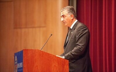 Profile view of Reza Pahlavi, Crown Prince of Iran, speaking from a podium during a Milton S Eisenhower Symposium at the Johns Hopkins University, Baltimore, Maryland, October 12, 2010. From the Homewood Photography Collection.