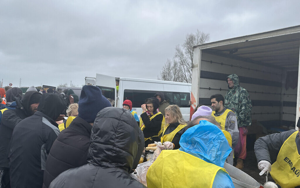 Marie van der Zyl, centre, helps with a food distribution to migrants  inside the Dunkirk camp