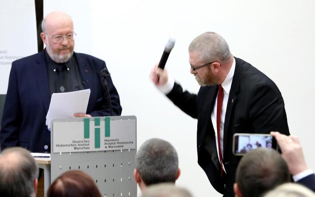 Polish-Canadian historian Jan Grabowski stands at the podium for a planned lectured as far-right lawmaker Grzegorz Braun of Poland’s Confederation party grabs the microphone and smashes it at the German Historical Institute in Warsaw, Poland, May 30, 2023. (Courtesy of Jan Grabowski)