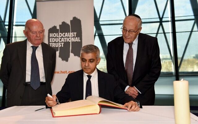 Holocaust survivors Ben Helfgott and Manfred Goldberg besides Mayor of London​ Sadiq Khan​, as he signs the Holocaust Educational Trust (UK)​ Book of Commitment at City Hall.