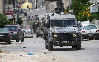 Israeli military vehicles surround a house, during the storming of the Balata refugee camp, east of Nablus, in the occupied West Bank. Israeli army forces raided the Balata refugee camp, stormed a house and bombed it, A 19-year-old Palestinian was killed and many of them were wounded.