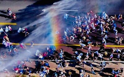 A rainbow from the water cannons over protesters at Ein Hemed Junction. Credit: Ilan Rosenberg