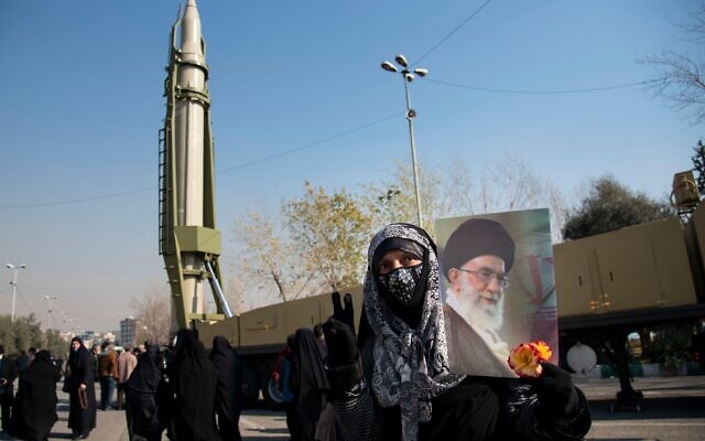A woman holds a poster of Supreme Leader of Iran, Ali Khamenei in front of Qiam, missile displayed in a missile capabilities exhibition by the paramilitary Revolutionary Guard a day prior to second anniversary of Iran's missile strike on U.S. bases in Iraq in Tehran, Iran, Friday, Jan. 7, 2022. (Credit Image: © Sobhan Farajvan/Pacific Press via ZUMA Press Wire) Credit: ZUMA Press, Inc./Alamy Live News