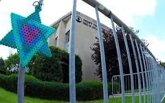 A Star of David hands from a fence outside the dormant landmark Tree of Life synagogue in Pittsburgh